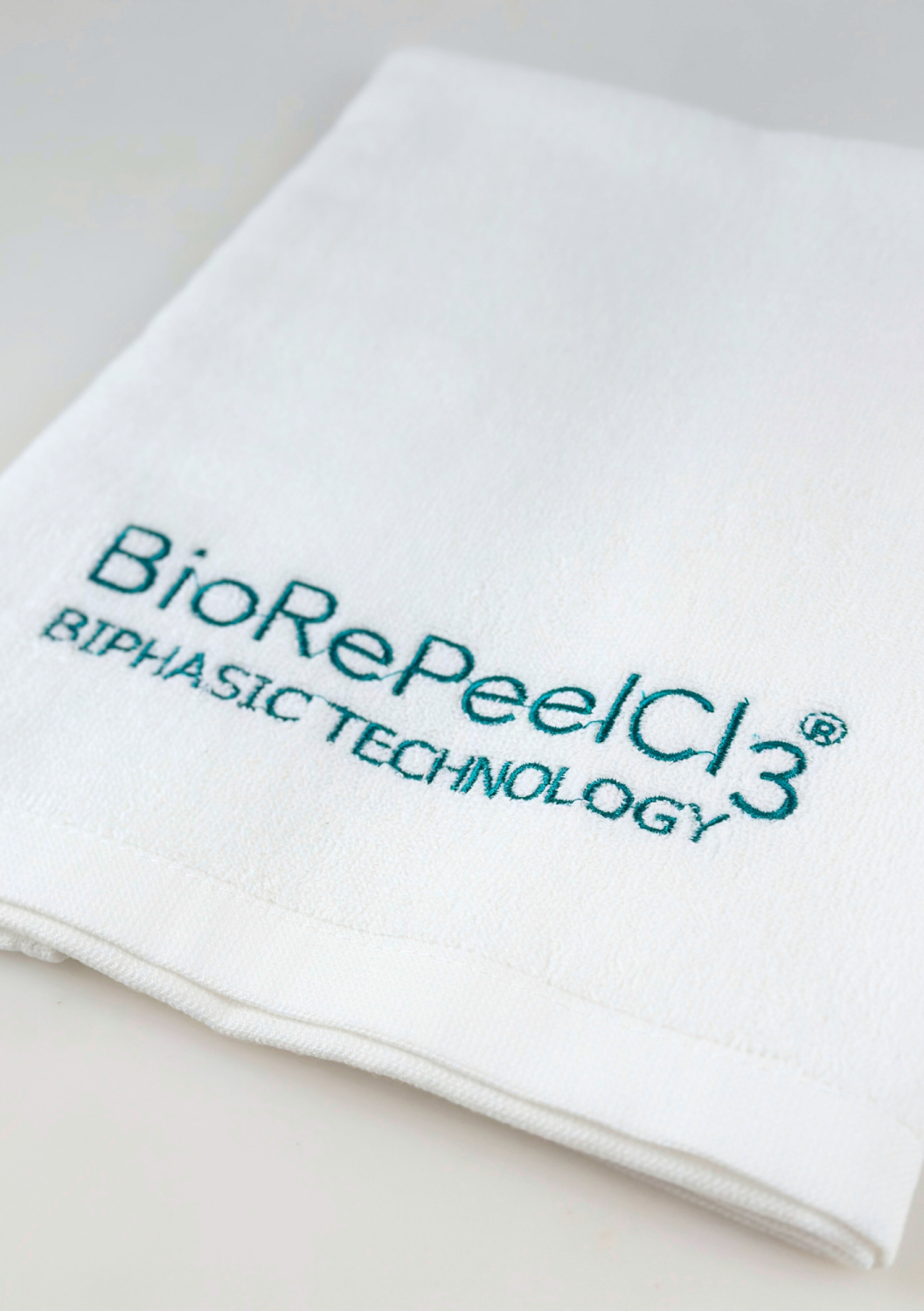 GIFT TOWEL BIOREPEEL SMALL, WHITE WITH BLUE-TO-GREEN LOGO 
40x60 cm Darček Malý bavlnený uterák s logom BioRePeel, biely s tyrkysovou výšivkou